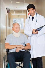 Image showing Doctor Standing By Patient On Wheel Chair