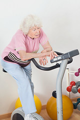 Image showing Tired Senior Woman Exercising On Bike