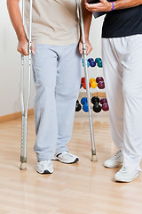 Image showing Man Holding Crutches Standing By Trainer