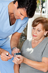 Image showing Male Nurse Measuring Glucose Level