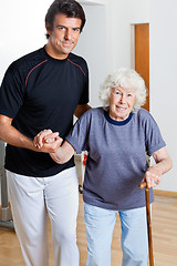 Image showing Trainer Assisting Woman With Walking Stick