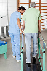 Image showing Male Therapist Assisting Senior Man To Walk With The Support Of