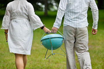 Image showing Couple Walking With Portable Barbeque