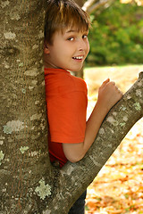Image showing Boy leaning against a tree