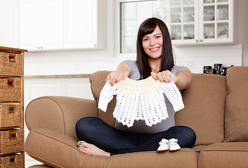 Image showing Expecting Mother with Baby Clothes