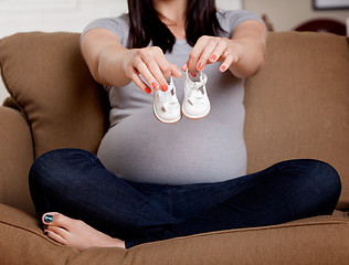 Image showing Pregnant Woman Holding Baby Shoes