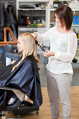 Image showing Stylist Curling Womans Hair