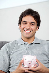 Image showing Happy Man Holding Piggybank