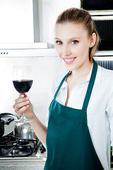 Image showing Woman Cooking in Kitchen with Red Wine