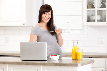 Image showing Pregnant Woman in Kitchen Eating Breakfast