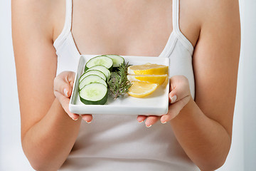 Image showing Woman With Plate Of Sliced Cucumber And Lime