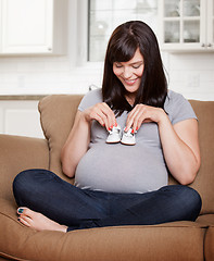 Image showing Expecting Mother Holding Shoes