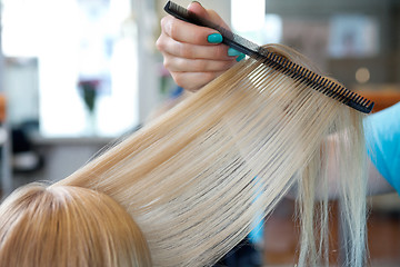 Image showing Hairdresser Combing Female Customer's Hair