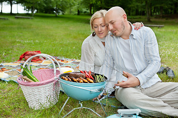 Image showing Mature Couple Cooking On An Outdoor Picnic