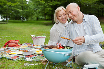 Image showing Couple Cooking Meat On Barbecue