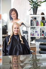 Image showing Hairdresser Curling Young Woman's Hair