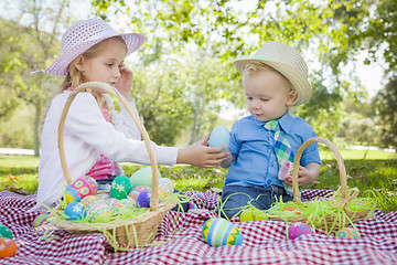 Image showing Cute Young Brother and Sister Enjoying Their Easter Eggs Outside