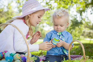 Image showing Cute Young Brother and Sister Enjoying Their Easter Eggs Outside