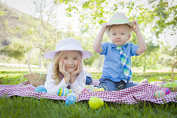 Image showing Cute Young Brother and Sister Enjoying Their Easter Eggs Outside