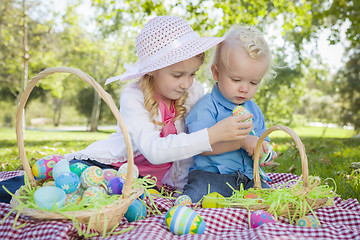 Image showing Cute Young Brother and Sister Enjoying Their Easter Eggs Outside