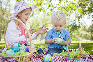 Image showing Cute Young Brother and Sister Enjoying Their Easter Eggs Outside