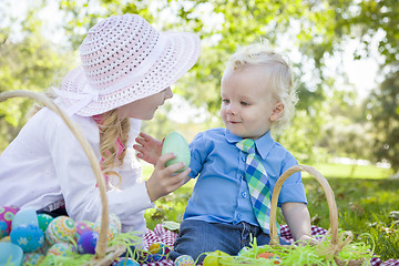 Image showing Cute Young Brother and Sister Enjoying Their Easter Eggs Outside