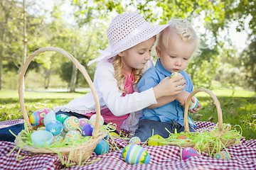 Image showing Cute Young Brother and Sister Enjoying Their Easter Eggs Outside