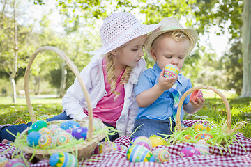 Image showing Cute Young Brother and Sister Enjoying Their Easter Eggs Outside