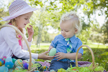 Image showing Cute Young Brother and Sister Enjoying Their Easter Eggs Outside