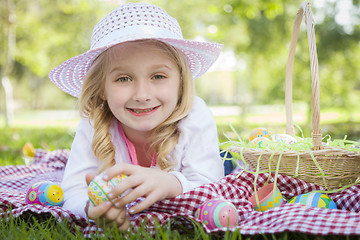 Image showing Cute Young Girl Wearing Hat Enjoys Her Easter Eggs