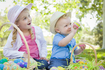 Image showing Cute Young Brother and Sister Enjoying Their Easter Eggs Outside