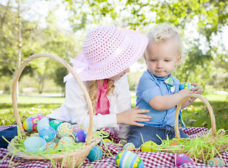 Image showing Cute Young Brother and Sister Enjoying Their Easter Eggs Outside