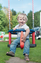 Image showing Swinging little boy in denim