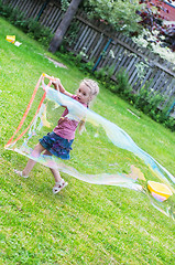Image showing Little girl making giant soap bubble
