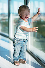 Image showing Happy baby boy near big window