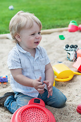 Image showing Small boy playing in sandpit