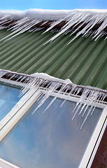 Image showing Many icicles hang on chalet´s roof 