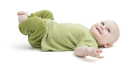 Image showing happy toddler lying on his back in green clothing