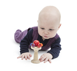 Image showing baby looking at wooden toy