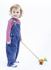 Image showing preschooler with toy standing in light background