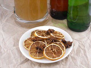 Image showing beer bottle with cinnamon and lemon on white plate