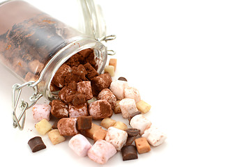 Image showing Cocoa and hot chocolate toppings spill from a glass jar