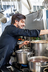 Image showing Chef stirring a huge pot of stew or casserole