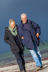 Image showing happy elderly senior couple walking on beach