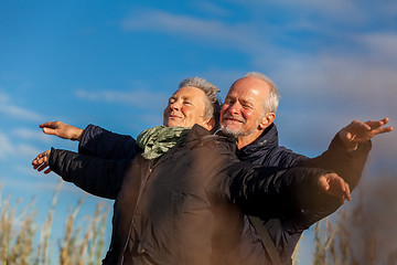 Image showing Elderly couple embracing and celebrating the sun