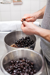 Image showing Chef preparing ingredients in a commercial kitchen