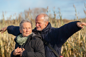 Image showing Elderly couple embracing and celebrating the sun