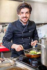 Image showing Chef cooking a vegetables stir fry over a hob