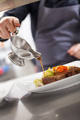 Image showing Chef plating up food in a restaurant