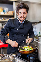 Image showing Chef cooking a vegetables stir fry over a hob